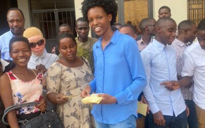 Mlle Elina Caroline ITEKA en train de distribuer les cartes d’assistance maladie aux batwa et albinos.