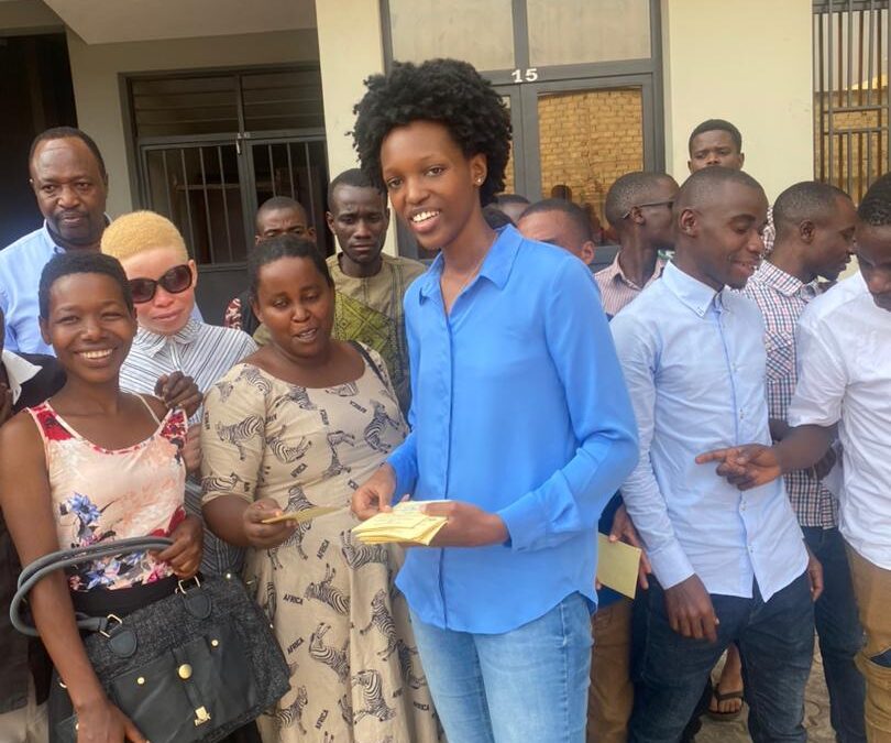 Mlle Elina Caroline ITEKA en train de distribuer les cartes d’assistance maladie aux batwa et albinos.